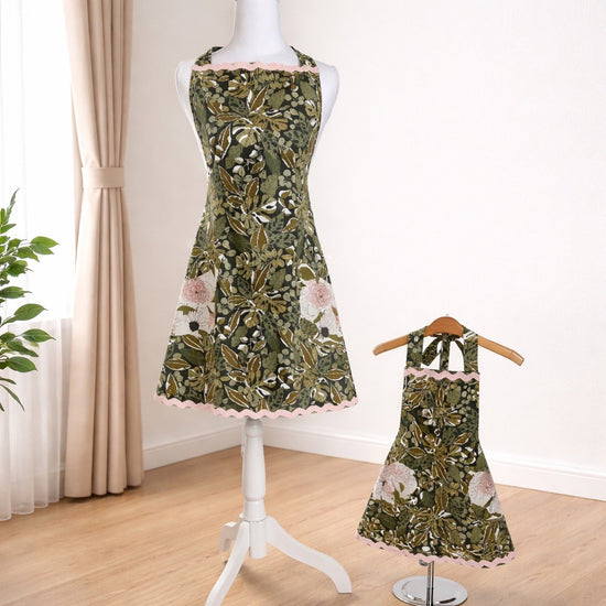 Adult apron with black and green leaf fabric and light pink trim